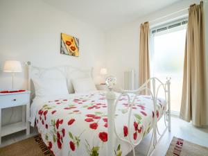 a white bedroom with a white bed with red flowers at Apartment Silvana-4 by Interhome in Matulji