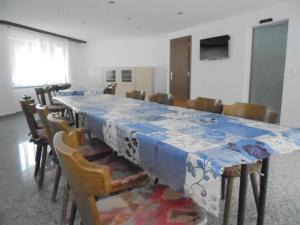 Zimmer mit einem langen Tisch mit Stühlen und einem blauen und weißen Tisch mit 6 dx in der Unterkunft Apartment Weideli by Interhome in Saas-Grund