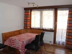 - une salle à manger avec une table, des chaises et des fenêtres dans l'établissement Apartment Silberdistel by Interhome, à Saas-Grund