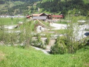 Blick auf ein Dorf mit einem Fluss auf einem Feld in der Unterkunft Apartment Kronenplatz 7 # 3 by Interhome in Lenk im Simmental