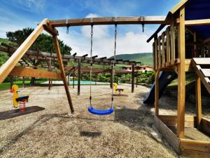 a playground with swings and a slide at Apartment Altaluna-5 by Interhome in Nisporto
