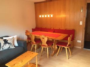 - une salle à manger avec une table, des chaises et un canapé dans l'établissement Apartment Butterfly by Interhome, à Adelboden