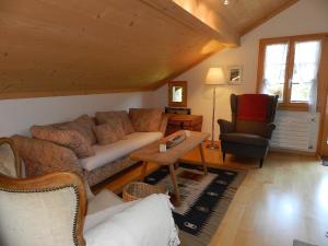 ein Wohnzimmer mit einem Sofa und einem Stuhl in der Unterkunft Apartment Im Wiesengrund by Interhome in Gstaad