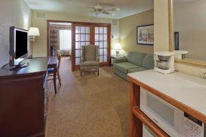 sala de estar con sofá y TV en Country Inn & Suites by Radisson, West Bend, WI, en West Bend