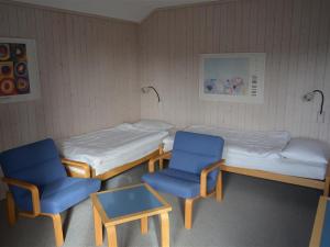 um quarto com duas camas e duas cadeiras e uma mesa em Apartment Arlette Nr- 30 by Interhome em Gstaad