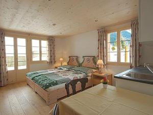 ein Schlafzimmer mit einem großen Bett und einem Waschbecken in der Unterkunft Apartment Mutthorn by Interhome in Lauenen