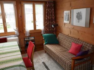 ein Wohnzimmer mit einem Sofa und bunten Kissen in der Unterkunft Apartment Mittaghorn by Interhome in Gsteig
