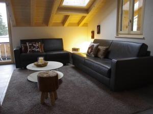 a living room with two black couches and a table at Apartment Anno Domini by Interhome in Adelboden
