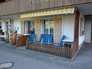 a group of blue chairs on the porch of a building at Apartment Eichhorn by Interhome in Zweisimmen