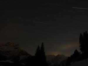 un cielo scuro con alberi e montagne sullo sfondo di Apartment Anno Domini by Interhome ad Adelboden