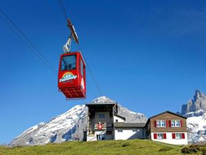 a ski lift in front of a snow covered mountain at Apartment Sörenweg 4 by Interhome in Engelberg