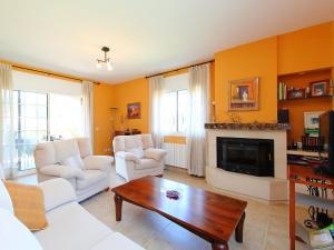 uma sala de estar com mobiliário branco e uma lareira em Holiday Home Marina by Interhome em Vidreres