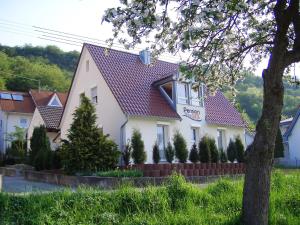 une maison blanche avec un toit rouge dans l'établissement Pension Fitnessoase, à Eußenheim