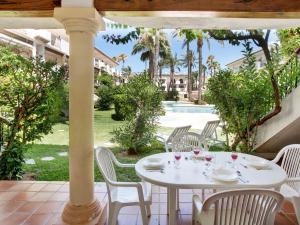 a white table and chairs on a patio with a pool at Apartment Bahia Azul in Denia