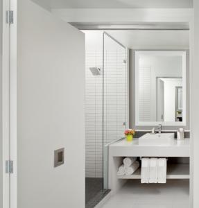 a white bathroom with a sink and a mirror at The Lumen in Dallas