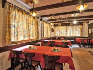 サース・アルマゲルにあるApartment Channa by Interhomeの赤いテーブルと椅子、カーテンのあるレストラン