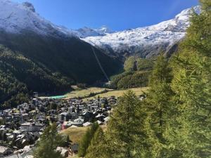 a small town in a valley with snow covered mountains at Apartment Mikado by Interhome in Saas-Fee