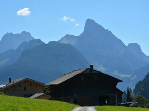 a barn on a hill with mountains in the background at Apartment Anne - Hochparterre by Interhome in Gstaad