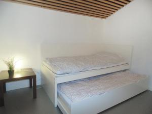 a white room with a bed and a table at Holiday Home Bbrik-1 by Interhome in Hoge Seine