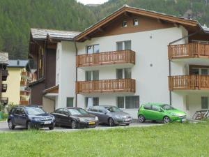 a group of cars parked in front of a building at Apartment Weideli by Interhome in Saas-Grund