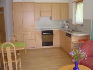 une cuisine avec des placards en bois et une table avec une table dans l'établissement Haus Le Mirage, à Saas-Fee