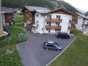 two cars parked in a parking lot in front of a house at Apartment Weideli by Interhome in Saas-Grund