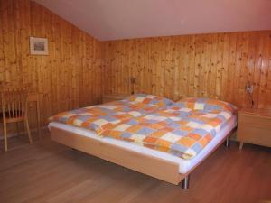 a bedroom with a bed and a wooden wall at Apartment Gilbachhöckli 2 by Interhome in Adelboden