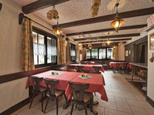 サース・アルマゲルにあるApartment Channa by Interhomeの赤いテーブルと椅子、窓のあるレストラン