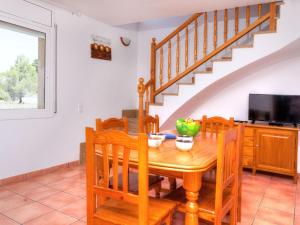 comedor con mesa de madera y TV en Villa Villa Mimosa I by Interhome en Les tres Cales