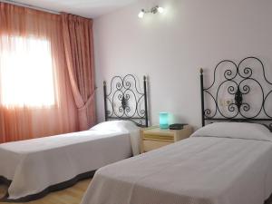 a bedroom with two beds and a window with at Apartment Blanes Playa by Interhome in Blanes