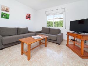 a living room with a couch and a tv and a table at Villa Villa Sant Jordi by Interhome in Les tres Cales