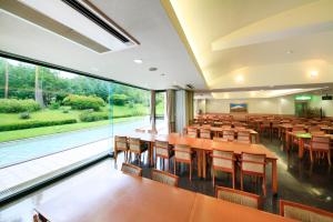 a lecture room with tables and chairs and a large window at Evergreen Fuji in Fujiyoshida