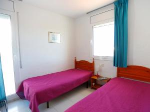 ミアミ・プラトーヤにあるHoliday Home Montalt VIII by Interhomeの小さな部屋のベッド2台 紫色のシーツ付