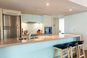 a kitchen with a stove top oven and a sink at Sullivans Cove Apartments in Hobart