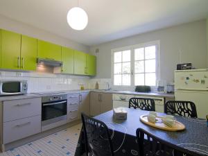 a kitchen with green cabinets and a table with chairs at Holiday Home Tal Mor by Interhome in Quiberon