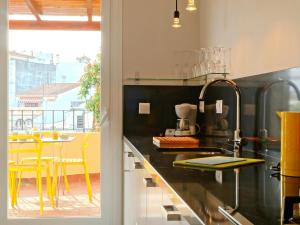 eine Küche mit einem Waschbecken und einem Tisch mit gelben Stühlen in der Unterkunft Apartment Plaza de las Flores by Interhome in Estepona