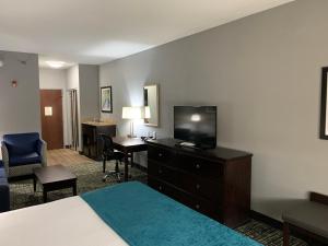 a hotel room with a bed and a flat screen tv at Best Western Plus Olive Branch Hotel & Suites in Olive Branch
