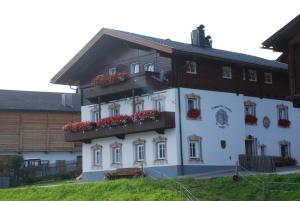 a white building with flower boxes on it at Bucherhof in Obertilliach