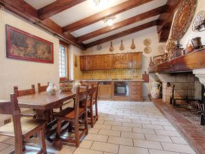 eine große Küche mit einem Holztisch und Stühlen in der Unterkunft Villa Olivo secolare by Interhome in Castelrinaldi