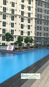 une grande piscine en face d'un grand bâtiment dans l'établissement SAN LORENZO PLACE 2BR 29-E by LARICO, à Manille