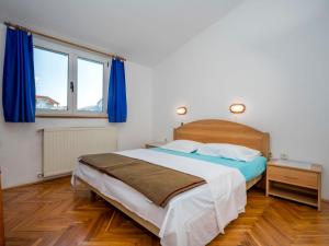 - une chambre avec un grand lit et des rideaux bleus dans l'établissement Apartment Hilde Blue-9 by Interhome, à Medulin