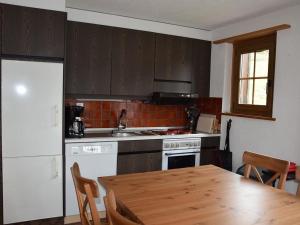 eine Küche mit einem Holztisch und eine Küche mit einem Herd in der Unterkunft Apartment Brandegg 4 by Interhome in Lenk im Simmental