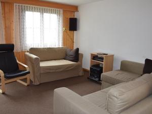 ein Wohnzimmer mit einem Sofa und einem Stuhl in der Unterkunft Apartment Brandegg 4 by Interhome in Lenk im Simmental