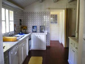 a kitchen with white cabinets and a sink at Holiday Home HOLLEBARDE in Léon