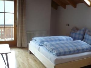 a bedroom with two beds with blue sheets and a window at Appartement Gasser in Anras