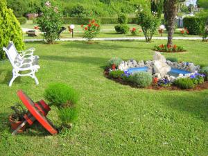 a garden with a bench and a pond with flowers at Apartment Cvjetko by Interhome in Rakalj +9 photos