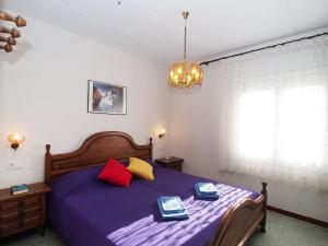 エンプリアブラバにあるVilla Alberes by Interhomeのベッドルーム1室(紫色のベッド1台、赤と黄色の枕付)