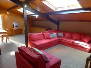 a living room with a red couch and a table at Holiday Home Lac et Forêt by Interhome in Le Moutchic