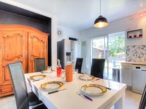 a dining room table with chairs and a kitchen at Holiday Home De la Plage by Interhome in Labenne