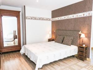 a bedroom with a white bed and a large mirror at Holiday Home Gîte du Linon by Interhome in Évran